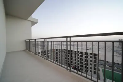 a balcony of a building with a view of the ocean at Spacious 1 BR in Peaceful Community in Dubai
