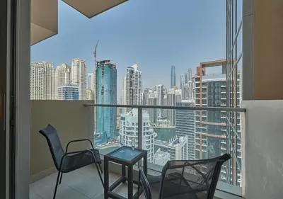 a balcony with chairs and a table and a view of a city at Dubai Marina Residences, Studio with Balcony Connected to Marina Mall in Dubai