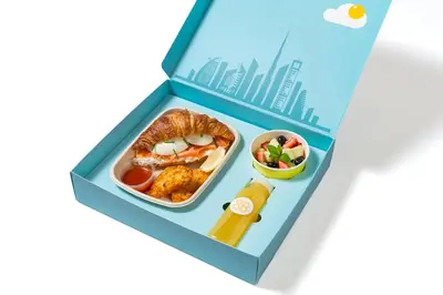 a bento box with a meal with food in it at Zada Tower 1BR with amazing Dubai Canal view in Dubai