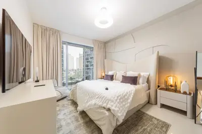 a white bedroom with a bed and a large window at EDEN'S Homes & Villas - Standpoint Residences in Dubai