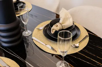 a table with two glasses of champagne and a napkin at EDEN'S Homes & Villas - Standpoint Residences in Dubai
