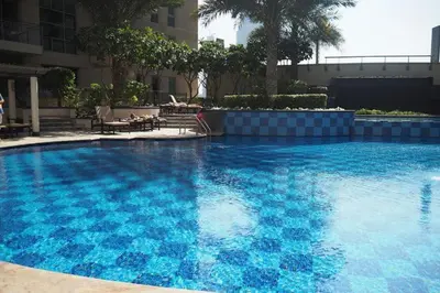 a large swimming pool with blue water in a building at EDEN'S Homes & Villas - Standpoint Residences in Dubai
