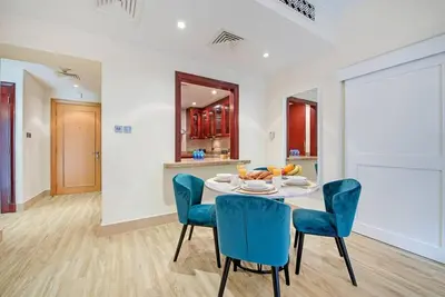 a dining room with a table and blue chairs at Stylish 2BR with Balcony Near Dubai Mall and Burj Khalifa in Dubai