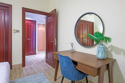 a dining room with a table and a mirror at Stylish 2BR with Balcony Near Dubai Mall and Burj Khalifa in Dubai
