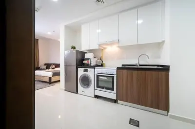 a kitchen with a washer and dryer in a room at Furnished Cozy Studio in Dubai