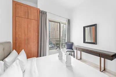 a bedroom with a bed and a desk and a window at FIRST CLASS 2BR with Exquisite Full Marina View in Dubai