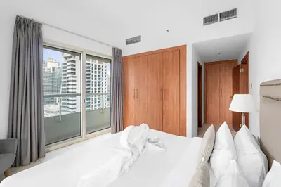 a bedroom with a white bed and a large window at FIRST CLASS 2BR with Exquisite Full Marina View in Dubai