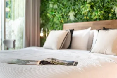 a magazine sitting on top of a white bed at Stylish Studio Walk to Dubai Mall & Burj Khalifa with Pool, Gym & Balcony in Dubai