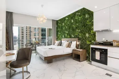 a bedroom with a bed and a green wall at Stylish Studio Walk to Dubai Mall & Burj Khalifa with Pool, Gym & Balcony in Dubai