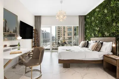 a large bedroom with a bed and a desk and a desk at Stylish Studio Walk to Dubai Mall & Burj Khalifa with Pool, Gym & Balcony in Dubai