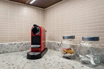 a kitchen counter with a toaster and two jars of food at Modern 2BR with Harbor Views, Pool, & Concierge in Dubai