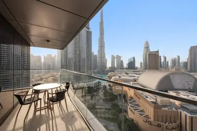 a balcony with a table and chairs and a view of a city at Modern 2BR with Harbor Views, Pool, & Concierge in Dubai