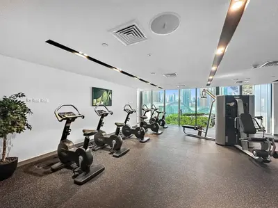 a gym with treadmills and exercise bikes in a room at Modern 2BR with Harbor Views, Pool, & Concierge in Dubai