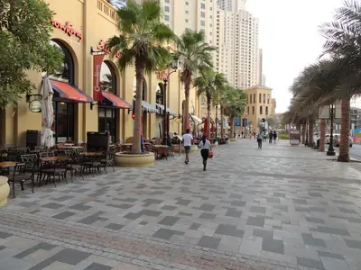 a city street with palm trees and tables and buildings at Amazing Sea View 2 bedroom Full Apartment in Dubai