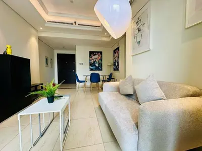 a living room with a couch and a table at 1BR + maid room Apartment in Downtown Dubai in Dubai