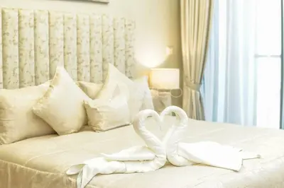 two white swans sitting on top of a bed at Elegant Studio at Aykon City Tower - C in Dubai