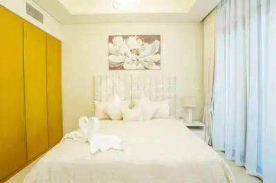 a bedroom with a white bed with a flower on it at Elegant Studio at Aykon City Tower - C in Dubai