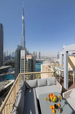 a balcony with a table with a bowl of fruit on it at The Signature Burj Khalifa View Residence with Terrace in Dubai