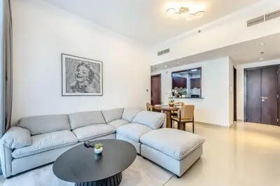 a living room with a couch and a table at Stylish 1 BR in The Medalist by PK Holidays in Dubai