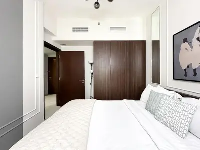 a bedroom with a large white bed in a room at Trophy - Blossom Suites w Balcony Garden & Canal View in Dubai