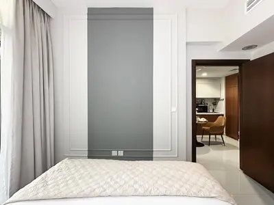 a bedroom with a bed with a glass wall at Trophy - Blossom Suites w Balcony Garden & Canal View in Dubai