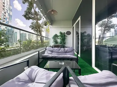 a balcony with two beds and a table on it at Trophy - Blossom Suites w Balcony Garden & Canal View in Dubai