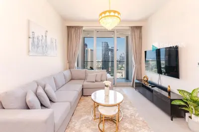 a living room with a large couch and a tv at Charming Apartment in Downtown Just Steps from Burj Khalifa & Dubai Mall by Bhavan Vacation Homes in Dubai