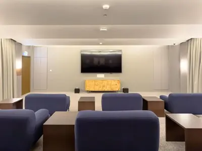 a conference room with blue chairs and a flat screen tv at Charming Apartment in Downtown Just Steps from Burj Khalifa & Dubai Mall by Bhavan Vacation Homes in Dubai