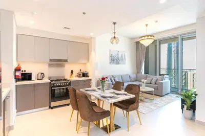 a kitchen and living room with a table and chairs at Charming Apartment in Downtown Just Steps from Burj Khalifa & Dubai Mall by Bhavan Vacation Homes in Dubai