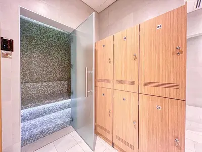 a bathroom with wooden cabinets and a walk in shower at Remarkable 2BR+storage in JBR with Sea View in Dubai