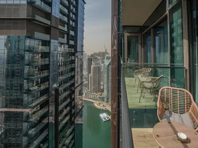 a balcony with a table and chairs and a view of the city at Livin' Holidays - Luxury apartment in Dubai Marina in Dubai