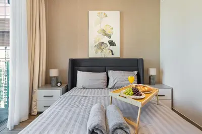 a bed with a table with a plate of food on it at Livin' Holidays - Luxury apartment in Dubai Marina in Dubai