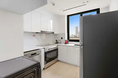 a kitchen with white appliances and a large window at Stunning modern 3BR apartment in JVC in Dubai