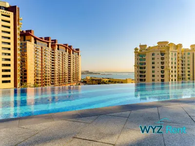a swimming pool in the middle of some buildings at Elegant 1BR in Palm Tower, Nakheel Mall, Sea View in Dubai