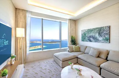 a living room with a couch and a large window at Elegant 1BR in Palm Tower, Nakheel Mall, Sea View in Dubai