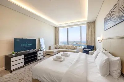 a hotel room with a large white bed and a couch at Palm Tower Luxury Studio W Stunning Sea View in Dubai