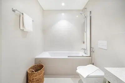 a white bathroom with a tub and a toilet at Silkhaus Sea and City View 1BDR in Marina Vista in Dubai
