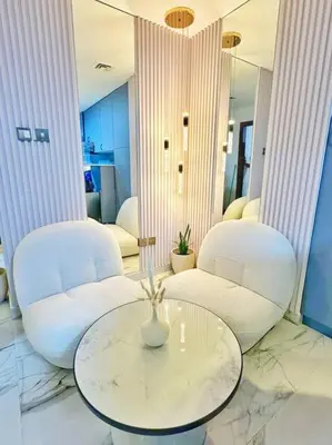 a living room with two white chairs and a table at Your Scenic Dream Vacation in Dubai