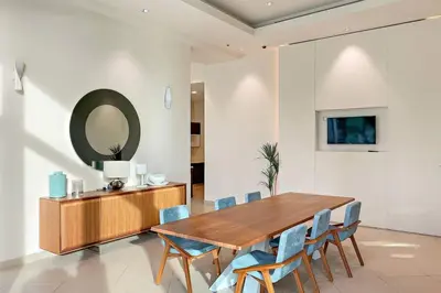 a dining room with a wooden table and blue chairs at FIRST CLASS 1BR Beautifully Furnished in Dubai