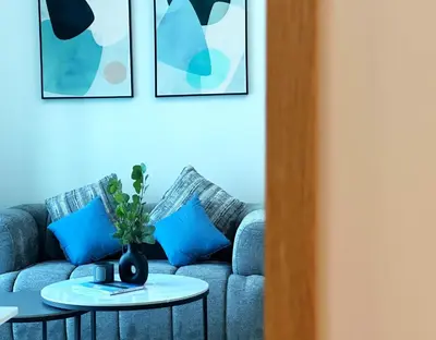 a living room with a blue couch with blue pillows at Lxury Brand New Studio w/ Balcony and Marina View in Dubai