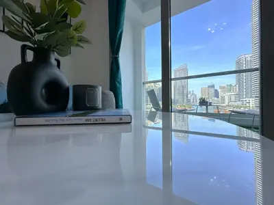 a vase sitting on a book on a table with a window at Lxury Brand New Studio w/ Balcony and Marina View in Dubai