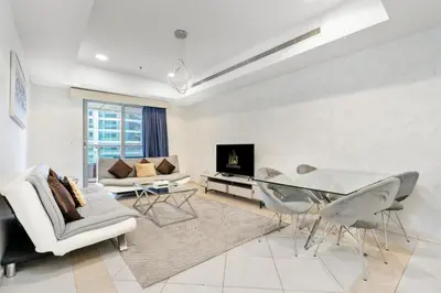 a living room with a glass table and chairs at Ahlan HH - Princess Tower - Elegant 1BR in Dubai Marina in Dubai