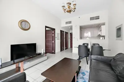 a living room with a couch and a tv and a table at StoneTree - Furnished 1 BR - Glitz 3 in Dubai