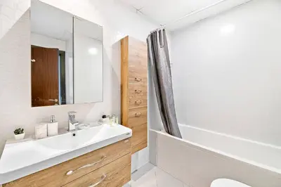 a bathroom with a sink and a tub and a mirror at StoneTree - Furnished 1 BR - Glitz 3 in Dubai