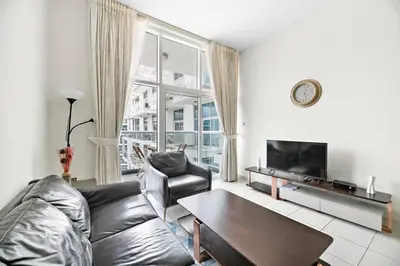 a living room with a leather couch and a table at StoneTree - Furnished 1 BR - Glitz 3 in Dubai