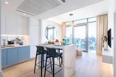 a kitchen with blue cabinets and a counter with stools at FIRST CLASS 1BR High Floor with Magical View in Dubai