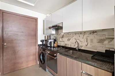a kitchen with a sink and a washer at Cozy Studio in Al Furjan in Dubai
