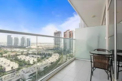 a balcony with a table and chairs and a view of a city at Comfortable Studio in Damac Hills in Dubai