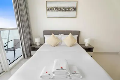 a bedroom with a bed with two towels on it at Cozy Studio in Damac Hills in Dubai