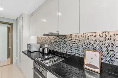 a kitchen with a stove and a counter top at High Floor Burj Khalifa & Sea View with stunning Infinity Pool in Dubai